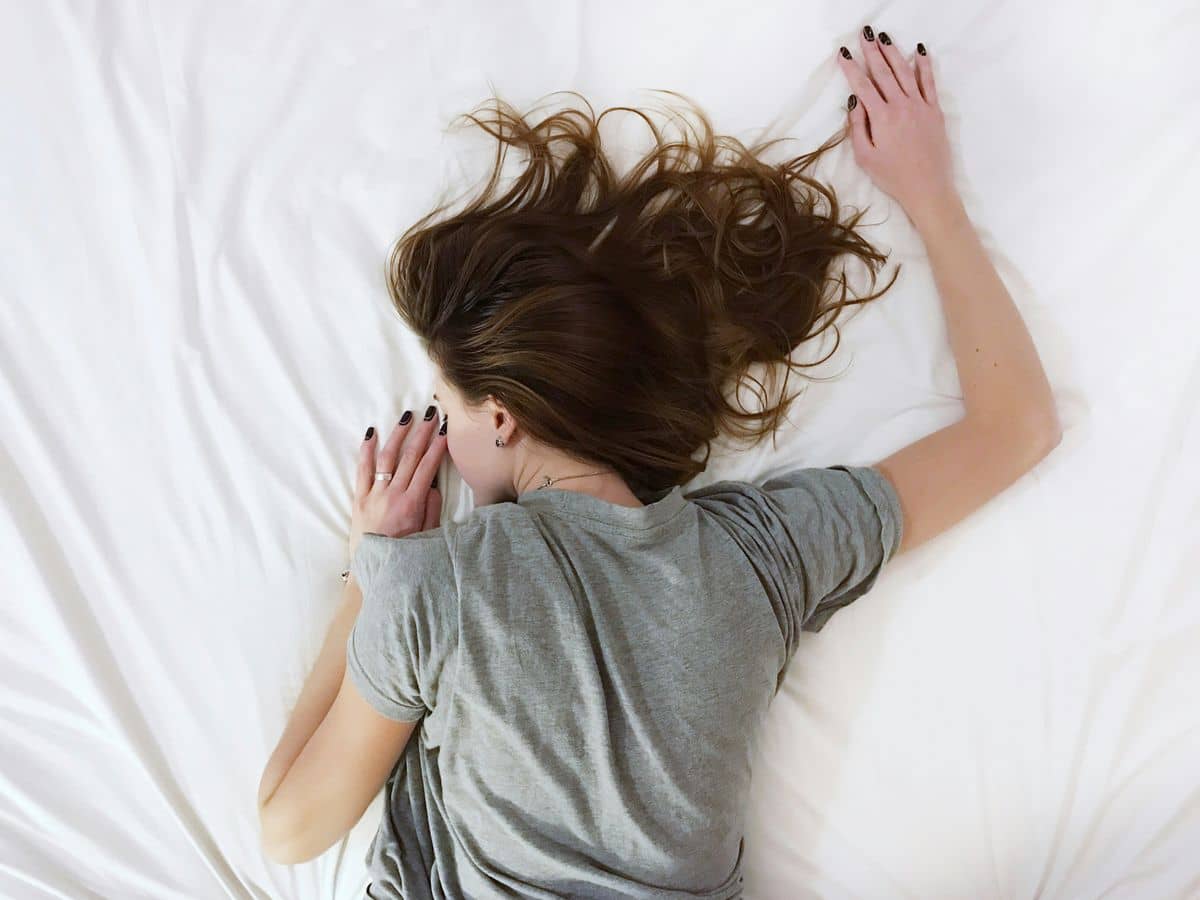 Person sleeping comfortably on a bed, representing the enhanced sleep quality with the Eight Sleep Pod 3 system.